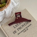 Dettaglio di una pinza per capelli a triangolo bordeaux con logo B dorato su libro - Rosso Vino - Clip Grande a Forma di T