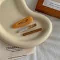Détail de trois barrettes en résine mate jaune et marbrée sur un plateau en céramique - Style Goutte Dépolie / Jaune Tulipe (Ensemble)