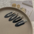 Detail of four black matte creaseless hair clips arranged on a ceramic tray for styling - Set of 4 / Black