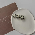 Detailweergave van de crèmekleurige smiley-haarklem op een minimalistische keramische schaal - Eendenbek haarclips / Wit Drie Glimlachen