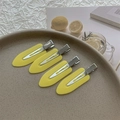 Lot de quatre barrettes à cheveux jaune mat disposées sur un plateau en céramique - Jaune
