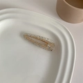 Detail of a resin hair clip with silver flakes on a white ceramic plate and gold metal base - Silver Foil Water Drop