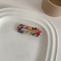 Close-up of marble pattern acetate hair clip with golden metal spring mechanism - Red Blue Marble Square