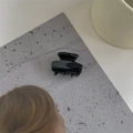Detail van een minimalistische zwarte haarklem van acetaat op een grijze ondergrond - Zwart
