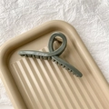 Detailed view of large olive green matte shark hair claw clip on a textured tray - Matte Blue Gray