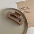 Detail shot of a matte brown rectangular hair claw clip on a ceramic tray décor - Matte Brown
