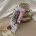 Detail of black multi-tooth hair styling comb in retail packaging on a desk - Hair Comb