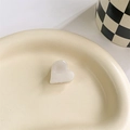 Dettaglio di una molletta a cuore color crema su un vassoio di ceramica elegante - Colore Sirena