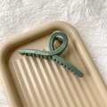Détail de la grande pince à cheveux vert Morandi avec design croisé et finition brillante - Vert Haricot Gris Brillant