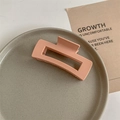 Macro shot of matte peach pink rectangular hair claw clip on a ceramic tray - Matte Light Orange