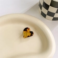 Macro shot of small heart-shaped tortoise shell hair claw clip on ceramic tray - Dark Leopard Print