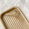 Détail d'une pince à cheveux transparente champagne au design croisé sur un plateau - Champagne Transparent