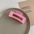 Macro detail of a matte pink rectangular claw clip with a hollow design on a ceramic plate - Matte Rose Pink