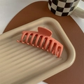 Macro detail of large matte coral pink shark hair claw clip with frosted texture - Matte Orange
