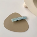 Macro shot of rectangular acetate hair clip with blue and pink marble texture - Blue