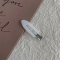 Primer plano de la pinza blanca de color caramelo con base metálica sobre papel - Blanco