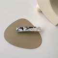 Macro detail of bicolored acetate hair clip with marble texture on leather base - Black & White