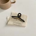 Dettaglio dell'elegante molletta per capelli nera e oro con design minimalista a torsione - Nero Piccolo