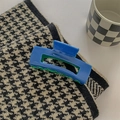 Detail van grote Klein blauwe acetaat haarklem op een achtergrond van houndstooth-stof - Blauw en Groen Patchwork