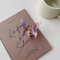 Detailed macro of a purple resin butterfly hair claw on a French book with vintage aesthetics - Mermaid Pink