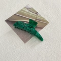 Macro di una pinza per capelli in acetato verde marmorizzato su cartolina d'epoca - Verde Cielo Stellato