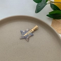 Detailed macro view of star-shaped marble acetate hair clip on a minimalist gray tray - Gold Dreamy Purple