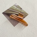 Détail d'une pince à cheveux en acétate marbré posée sur une carte rétro verte - Pince Triangulaire Oblique à Rayures Rouges