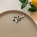 Dettaglio di un fermaglio a stella in acetato con motivo marmorizzato bianco e nero su vassoio - Argento Bianco e Nero