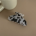 Details einer großen Acetat-Haarklammer mit grauem Marmormuster auf Leder - Schwarz-Weißer Leopardenprint