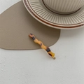 Close-up of tortoise shell pattern wavy hair clip with gold metal base on leather - Vintage Tortoiseshell