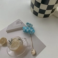Close-up of blue and white checkered mini hair claw clip with mirror finish on flat lay - Blue