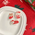 Dettaglio delle mollette natalizie in acrilico con motivi di Babbo Natale e renne festive - US 5
