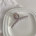 Detail of lilac enamel claw clip in acrylic with gold spring on a ceramic plate - Iced Coffee