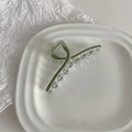 Detailed view of sage green acrylic shark hair claw clip on a white ceramic tray - Mustard Green