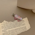 Detail shot of heart-shaped pink resin hair clip on vintage paper with metal clip back - Iridescent Pink (Silver Clip)