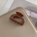 Dettaglio macro della pinza per capelli in acetato cioccolato con incisione a mano - Viola