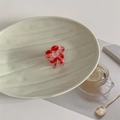 Dettaglio di un piccolo fermaglio per capelli a fiore rosso in acetato su piatto bianco - Marmo Rosso