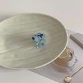 Dettaglio molletta a fiore in acetato marmorizzato blu e bianco su vassoio decorativo - Blu