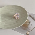 Detailed macro shot of a purple marble acetate flower hair claw clip on a stylish plate - Ink Pattern