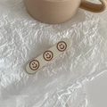 Detail of cream rectangle hair clip with three brown smiley faces on white paper - Smile Printed - White