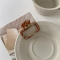 Detail view of a square acetate claw clip with blue and brown marble texture on a bowl - Light Blue