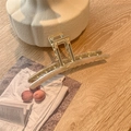 Macro detail of a 13cm oversized gold metal hair claw clip with acetate marble inlay - Rice Green Acetate
