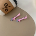 Dettaglio di fermagli per capelli a forma di bassotto rosa e grigio su base in pelle - Cane con Impermeabile Rosa