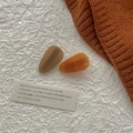 Gros plan de barrettes goutte d'eau en acétate marron et ambre sur pull en maille - Série Acétate Café