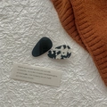 Détail des barrettes en acétate noires et effet marbré sur fond textile blanc - Série Acétate Noir