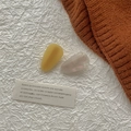 Gros plan de deux barrettes en forme de goutte en jaune gingembre et blanc irisé - Série Acétate Jaune