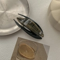 Close-up of marble pattern acetate hair claw clip with dark olive and black textures - Brown Gray Wood Grain