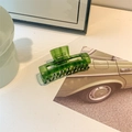 Close-up of dark green acetate hair claw clip with vertical striped texture on white table - Large Rectangle
