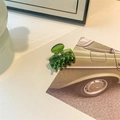 Detailed close-up of dark green acetate hair claw clip on a minimalist desk with card decor - Small Ribbed Claw