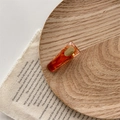 Dettaglio molletta in resina ambrata con foglie d'oro su vassoio di legno elegante - Modello Trapezoidale / Ambra Trapezio